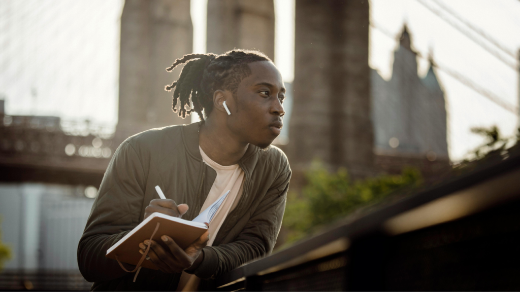 man journaling out in the city