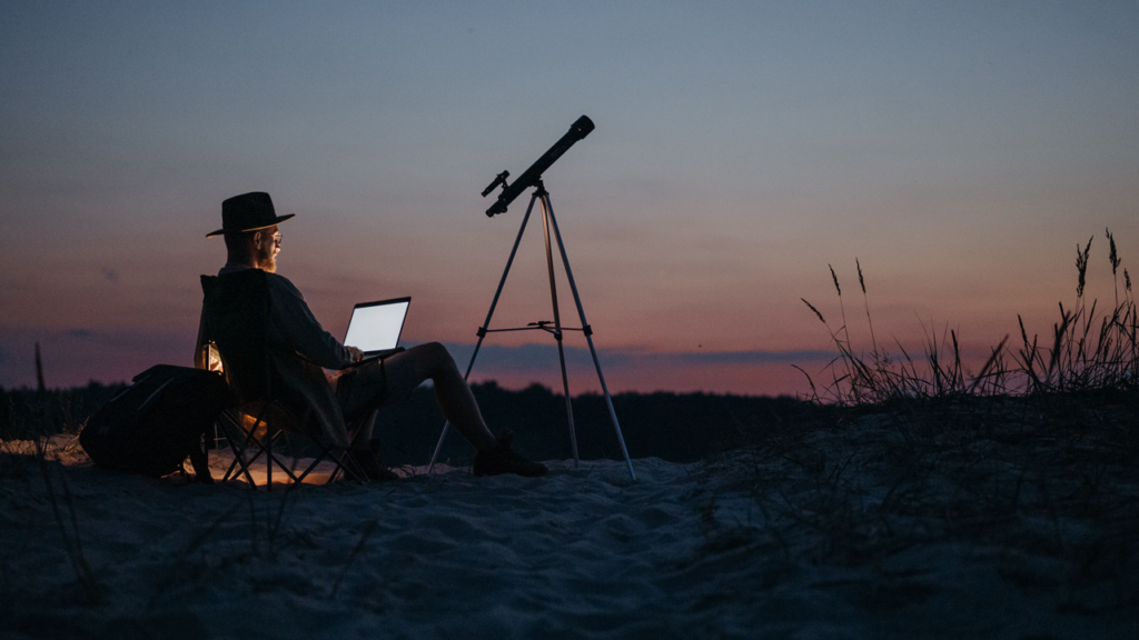 Man writing on a laptop in the outdoors at sunrise